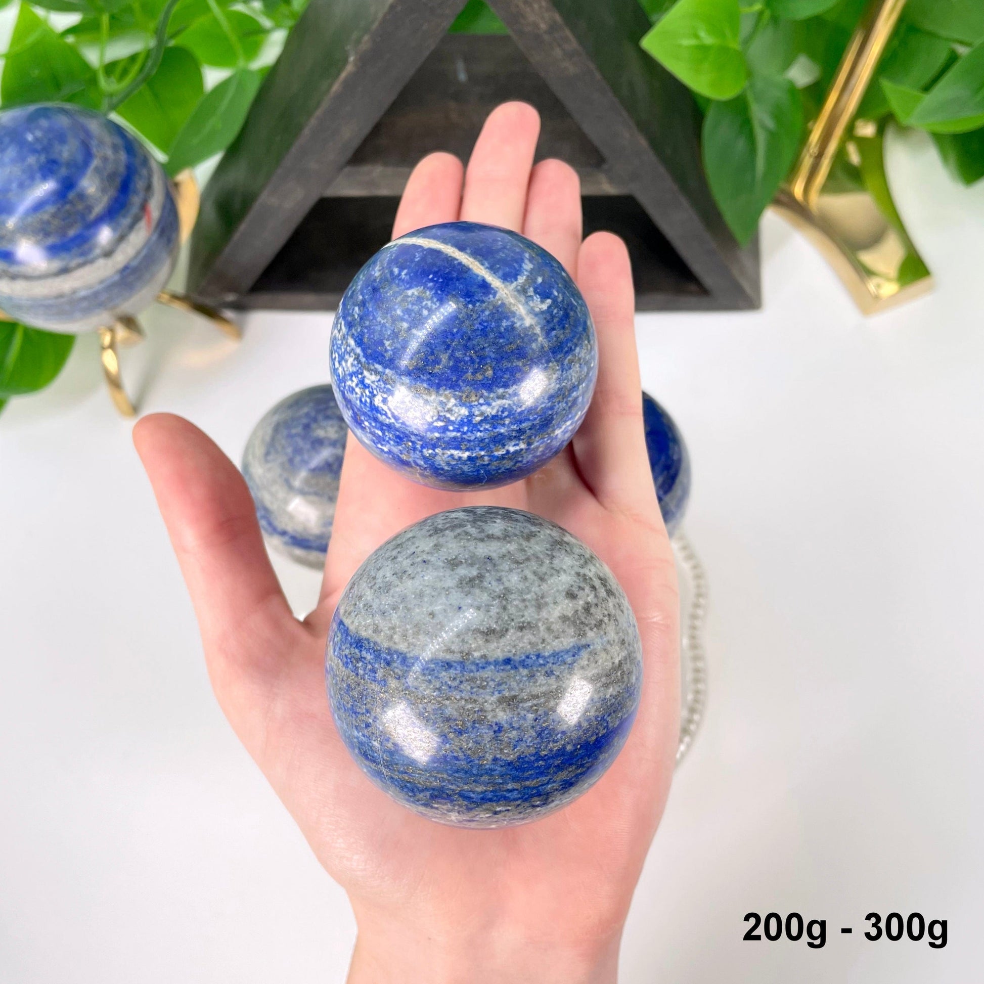 two 200g - 300g lapis lazuli polished spheres in hand 
