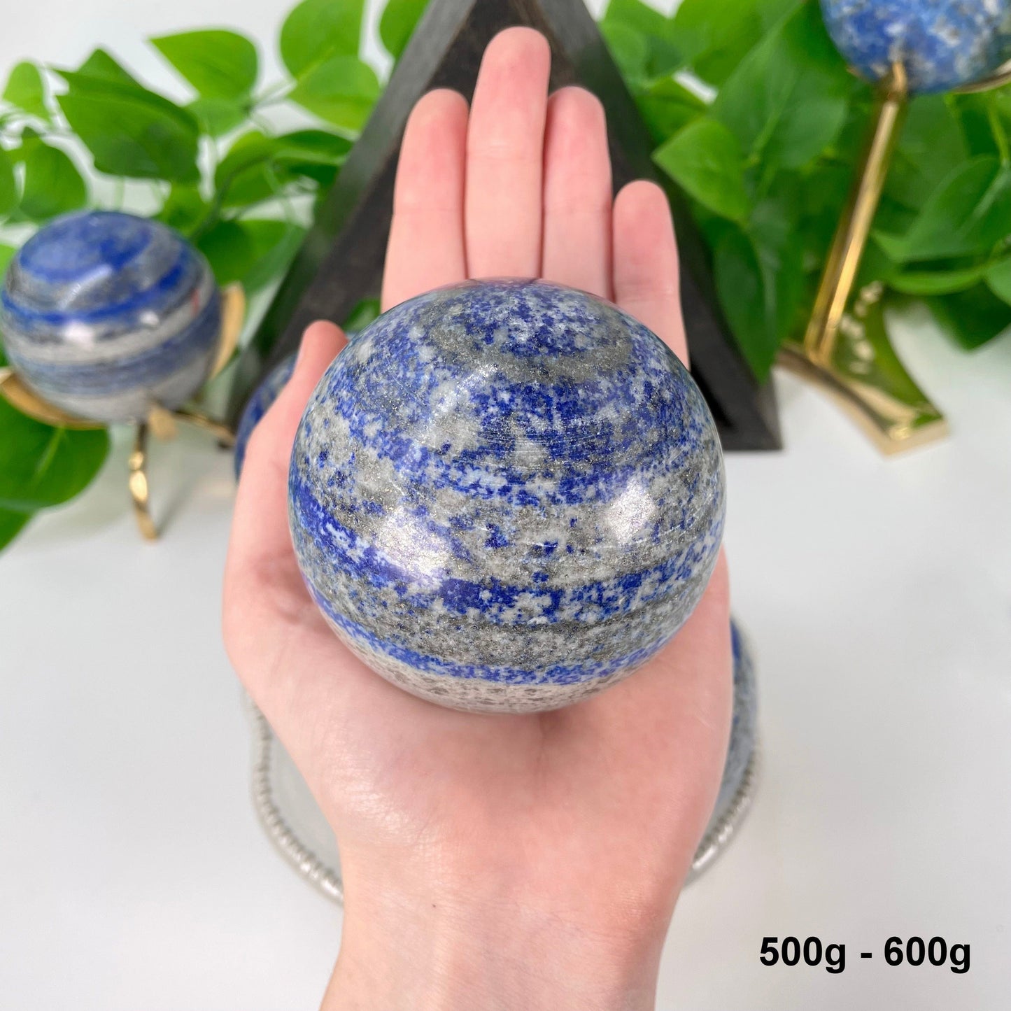one 500g - 600g lapis lazuli polished sphere in hand 