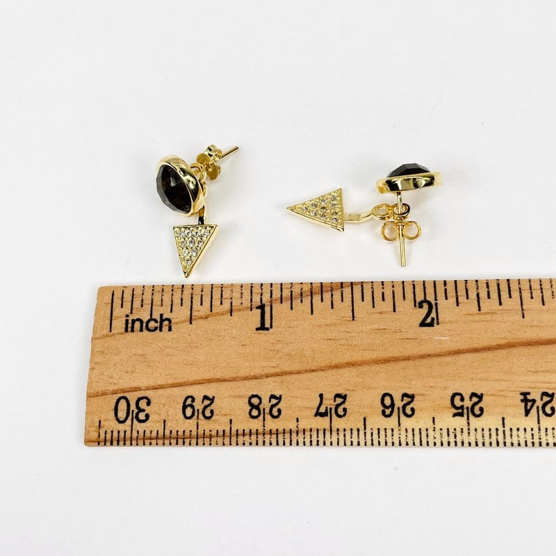 earrings next to a ruler for size reference 