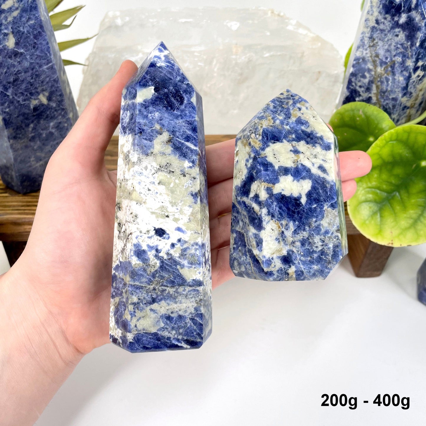 two 200g - 400g sodalite polished points in hand for size reference and possible variations
