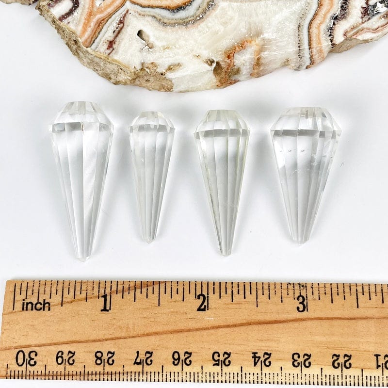 pendulums next to a ruler for size reference 