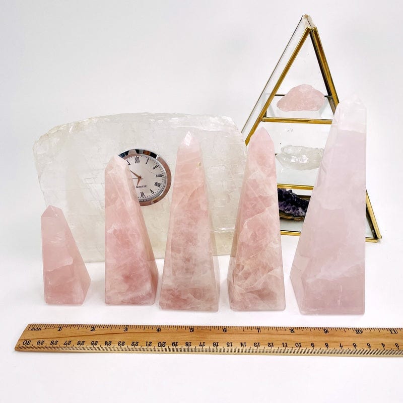 rose quartz obelisk next to a ruler for size reference 