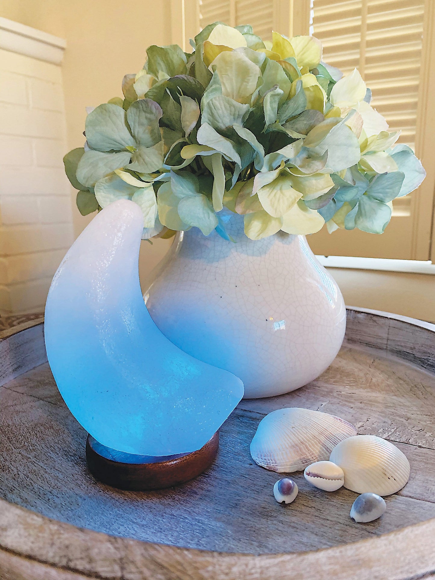 Moon shaped Himalayan Salt Lamp showing the changing color light, here in blue