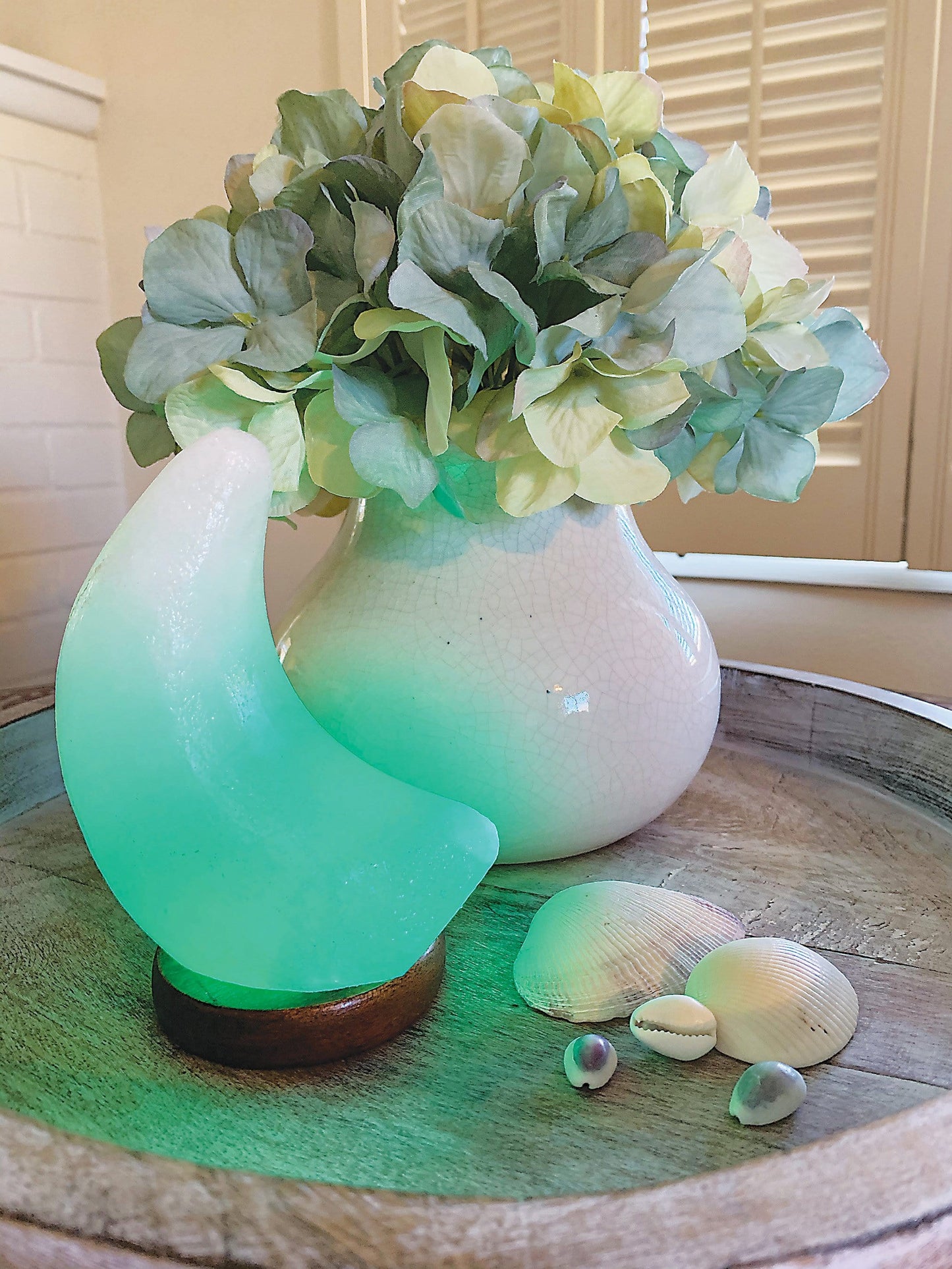 Moon shaped Himalayan Salt Lamp showing the changing color light, here in green