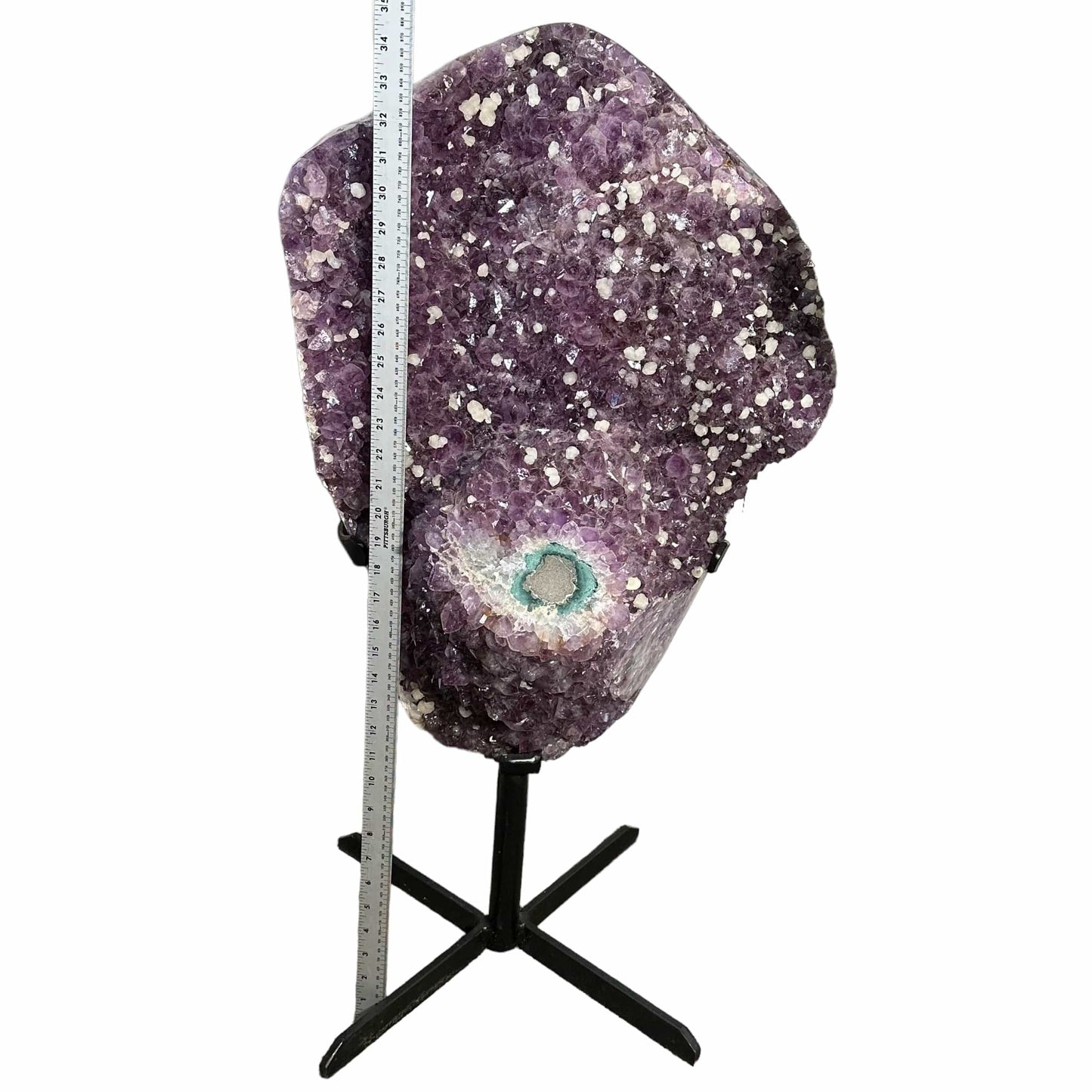 amethyst on stand next to a ruler for size reference 