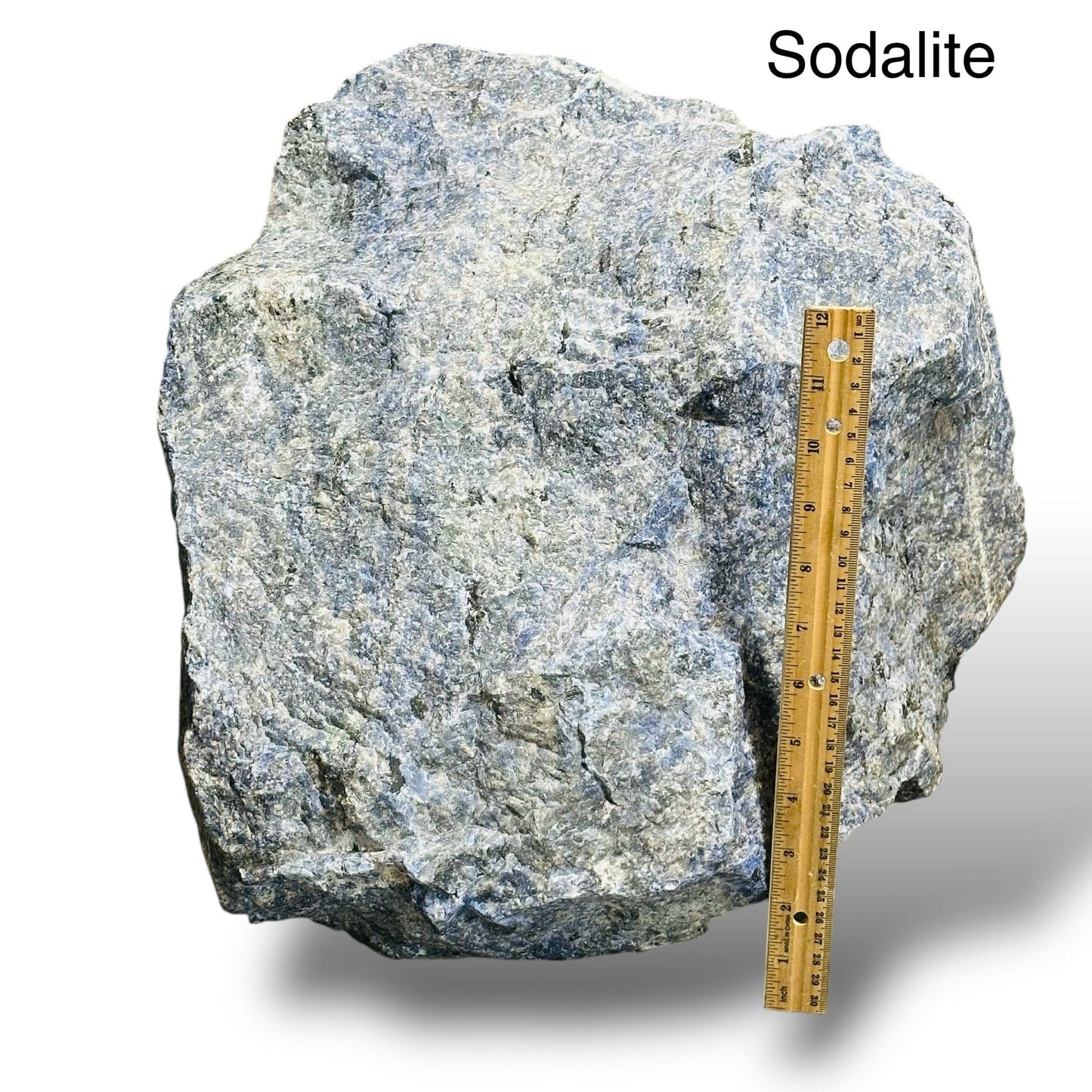large sodalite rough stone crystal next to a ruler for size reference 