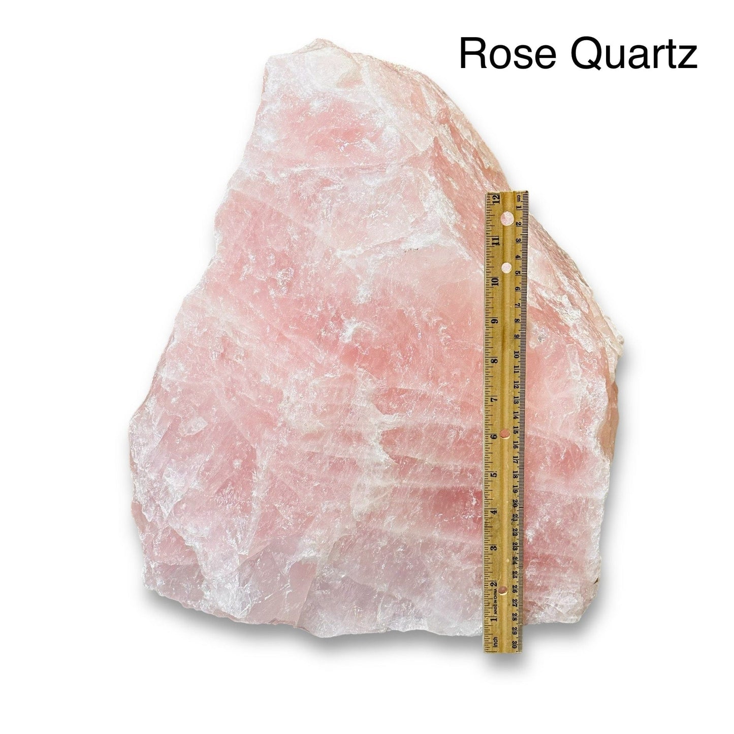 large rough stone crystal next to a ruler for size reference 