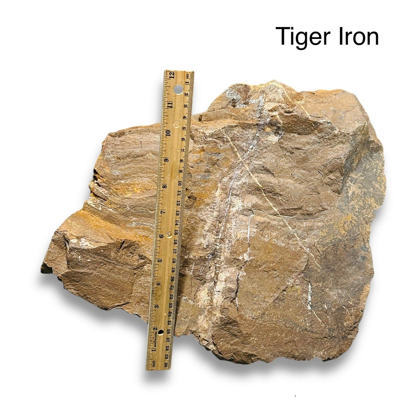 large rough stone crystal next to a ruler for size reference 