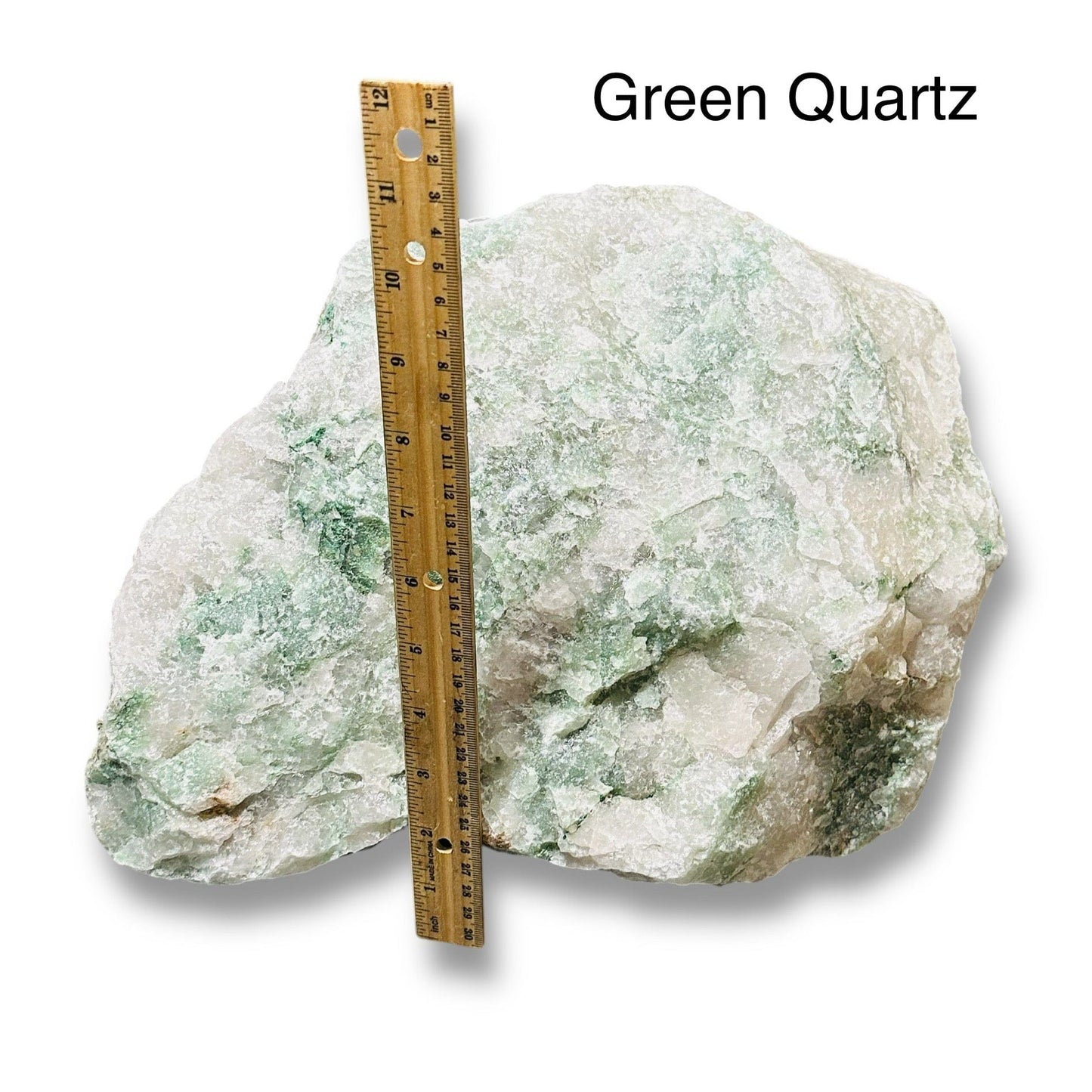 large rough stone crystal next to a ruler for size reference 