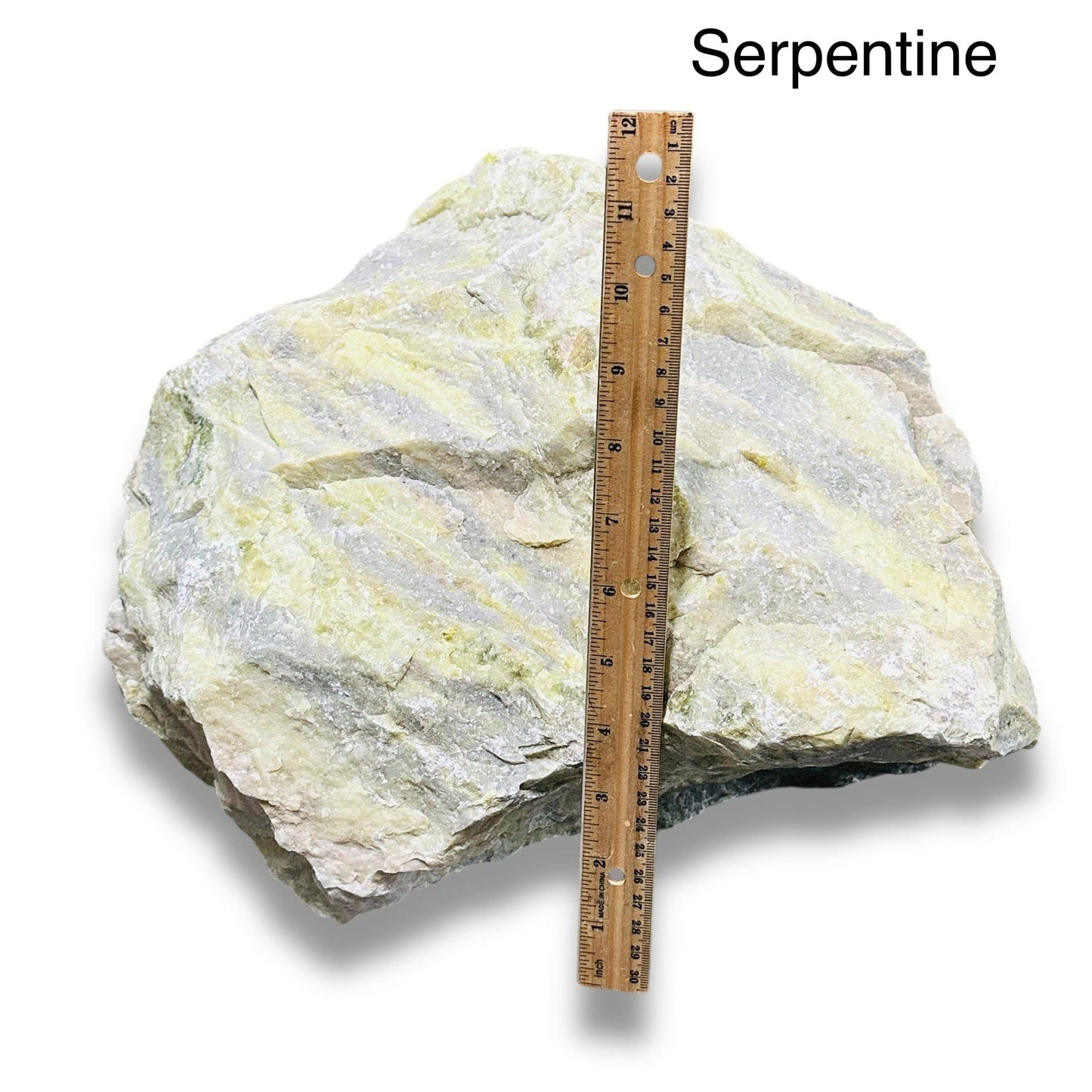 rough stone crystal next to a ruler for size reference 
