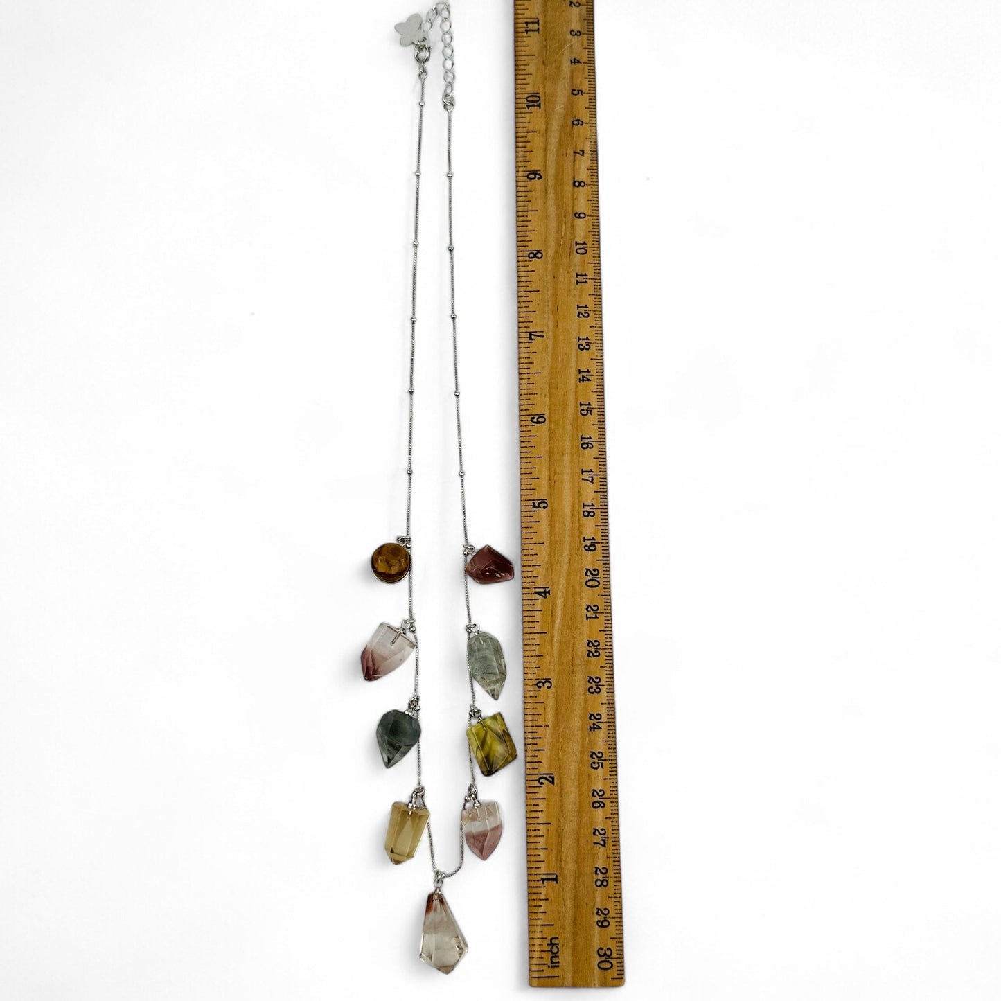 necklace next to a ruler for size reference 