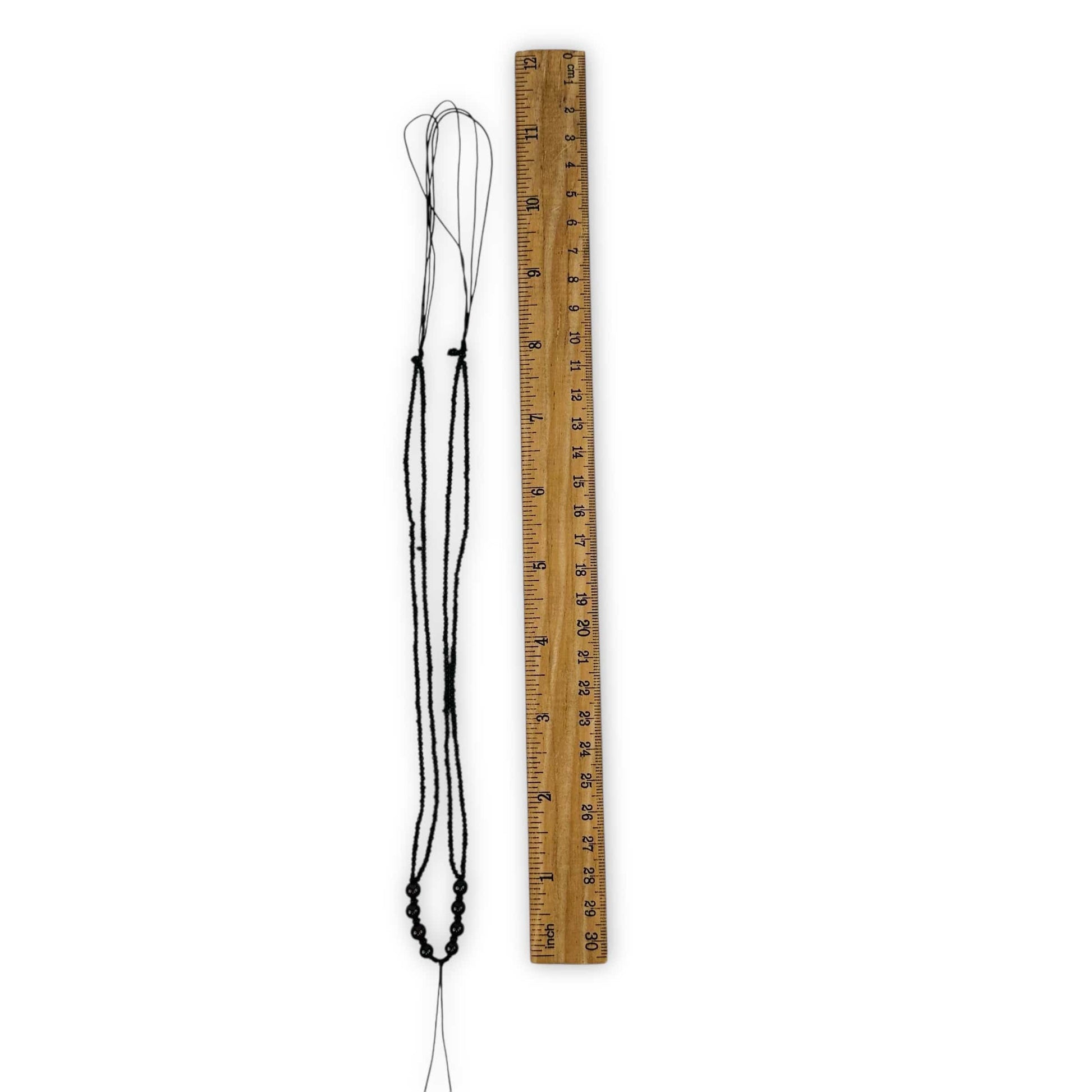 necklace displayed next to a ruler for size reference 
