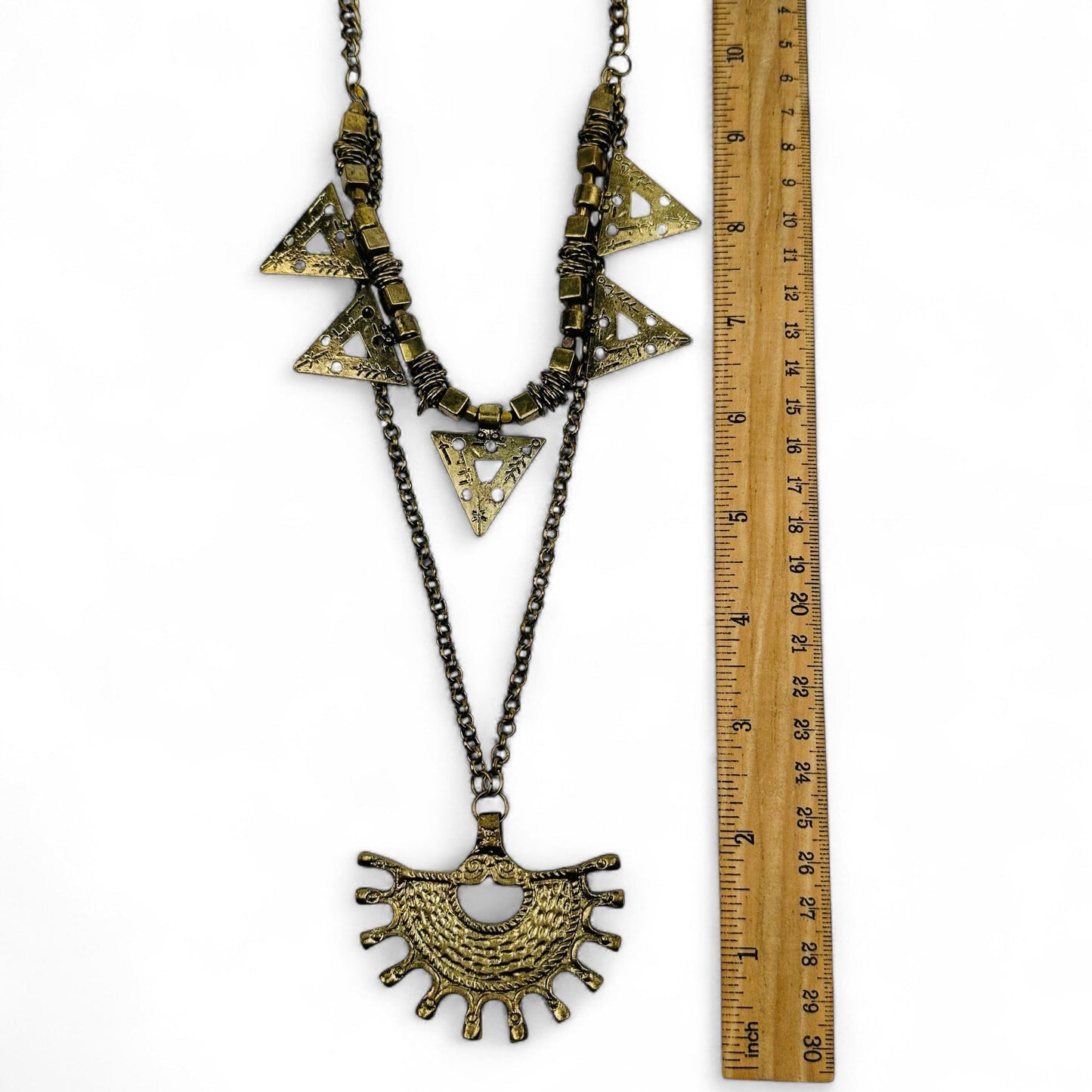 necklace charms next to a ruler for size reference 