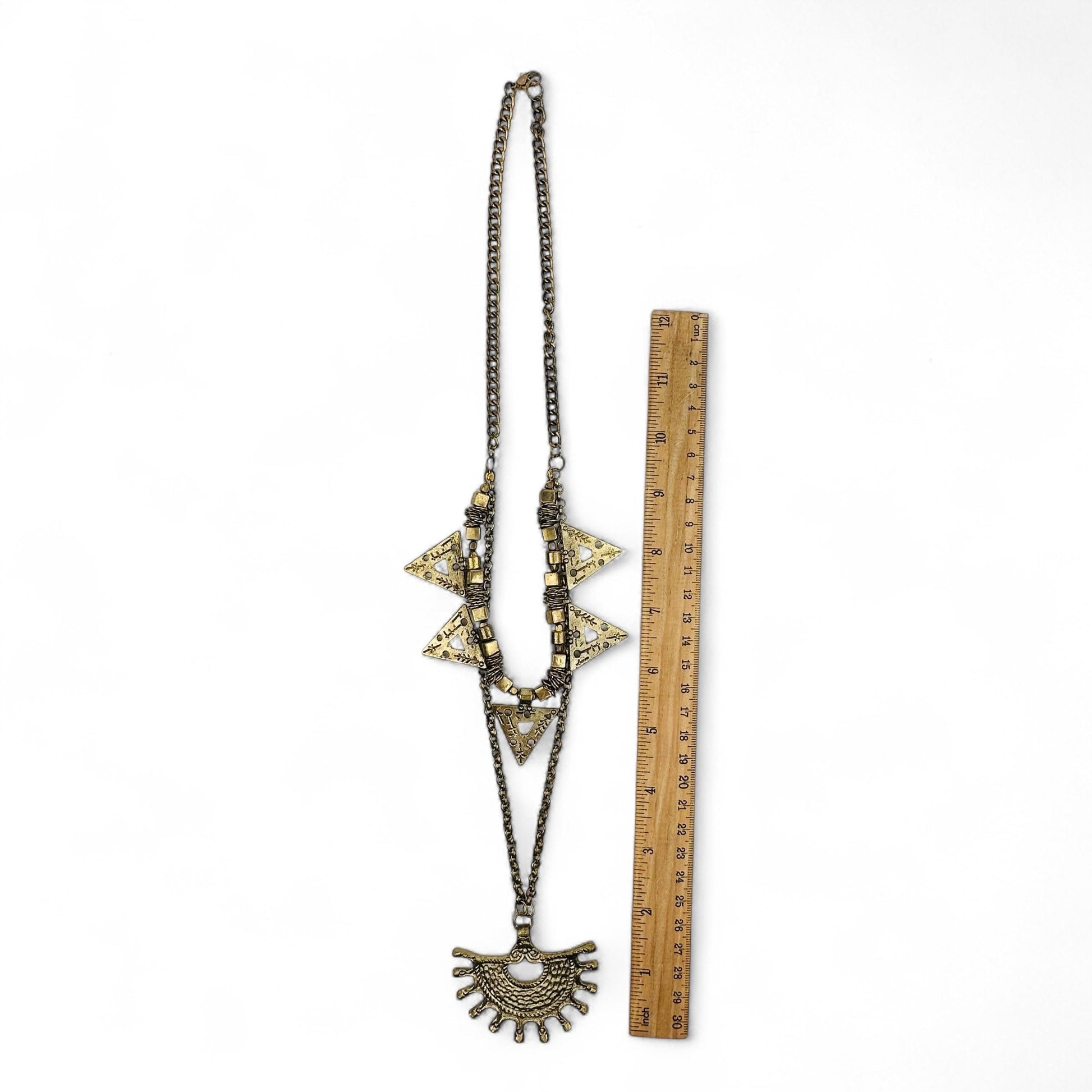 necklace next to a ruler for size reference 