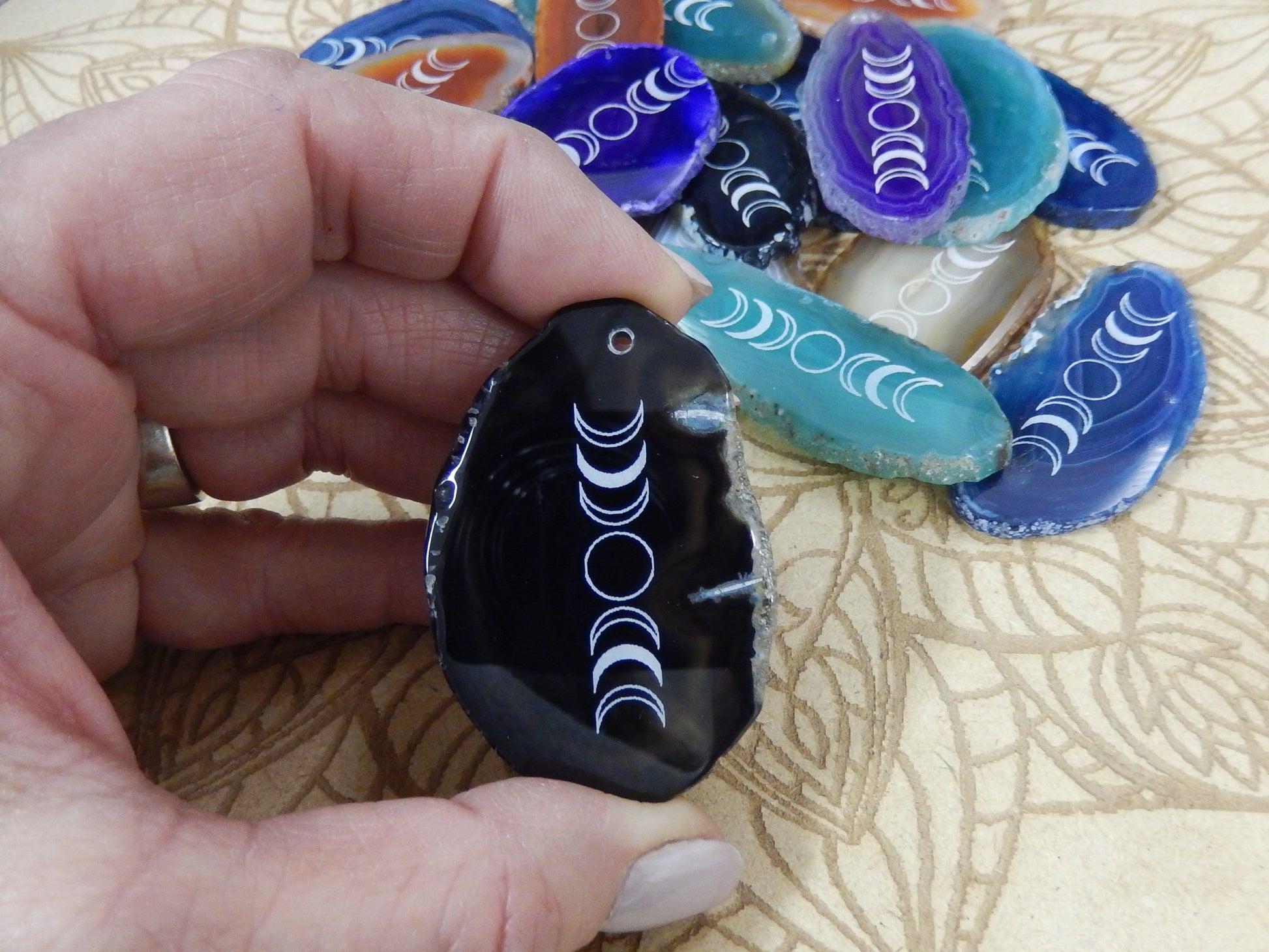 Picture of one of our black agate slices being held for size reference.