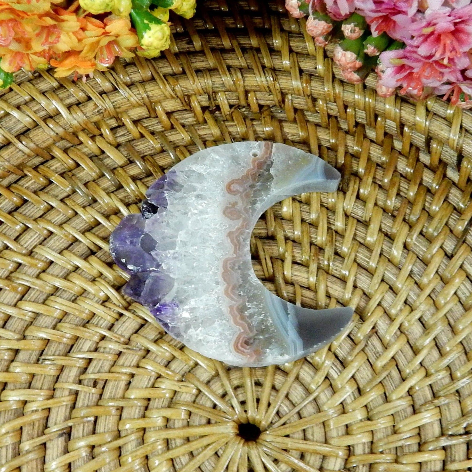 large drilled amethyst half moon with decorations in the background
