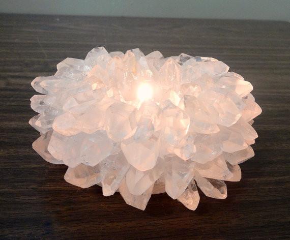 crystal quartz point candle holder with a candle lit in it