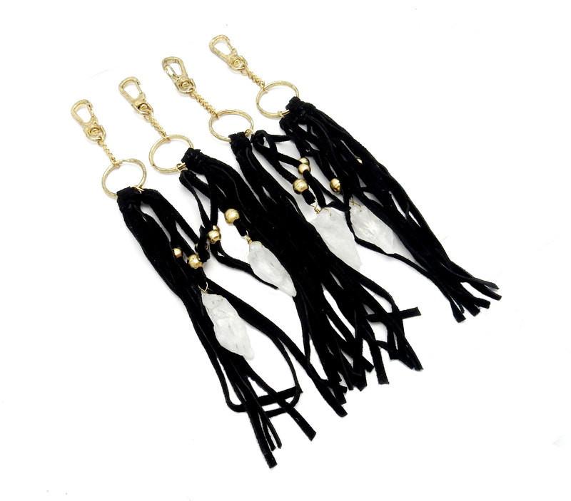 angled shot of 4 crystal keychain with black leather on white background