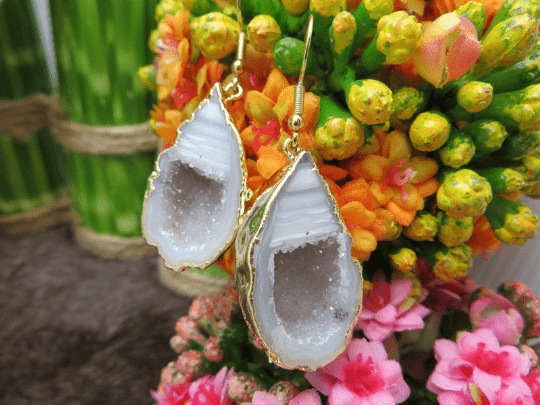 Close up of one agate geode druzy earring pair. Decoration in the background.