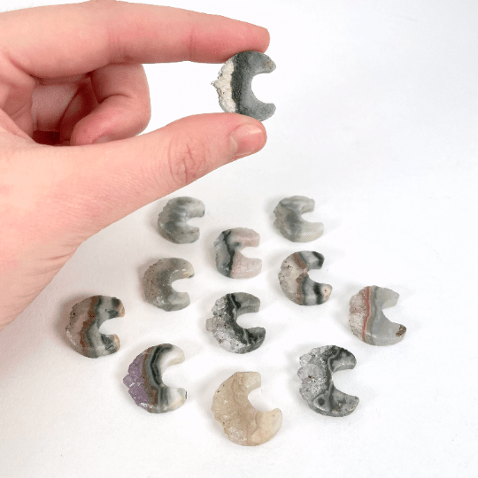 hand holding up amethyst moon crescents with more in the background