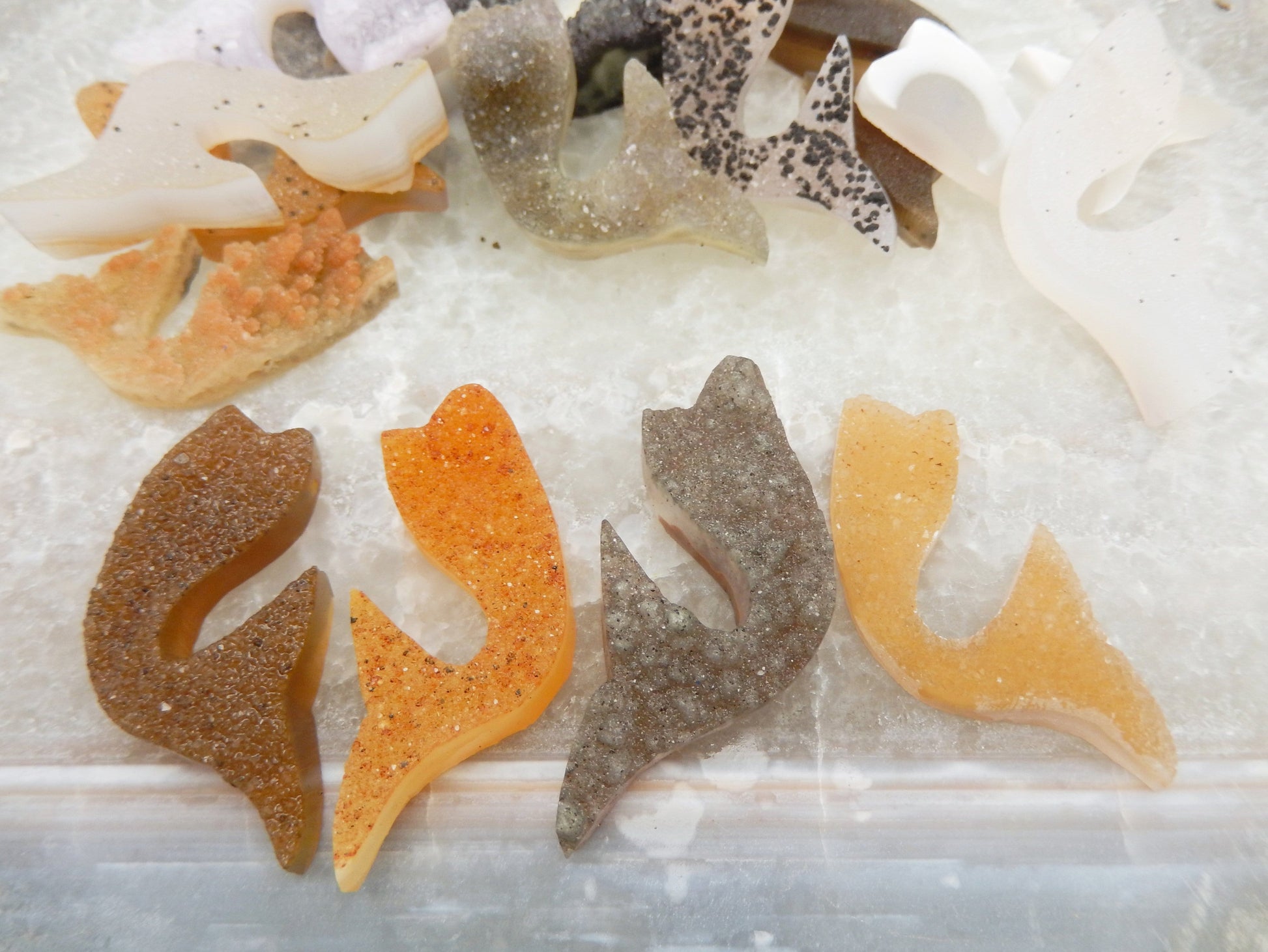 Druzy Cluster Mermaid Tail  Cabochon displayed to show various colors such as tan gray white orange yellow black spotted brown