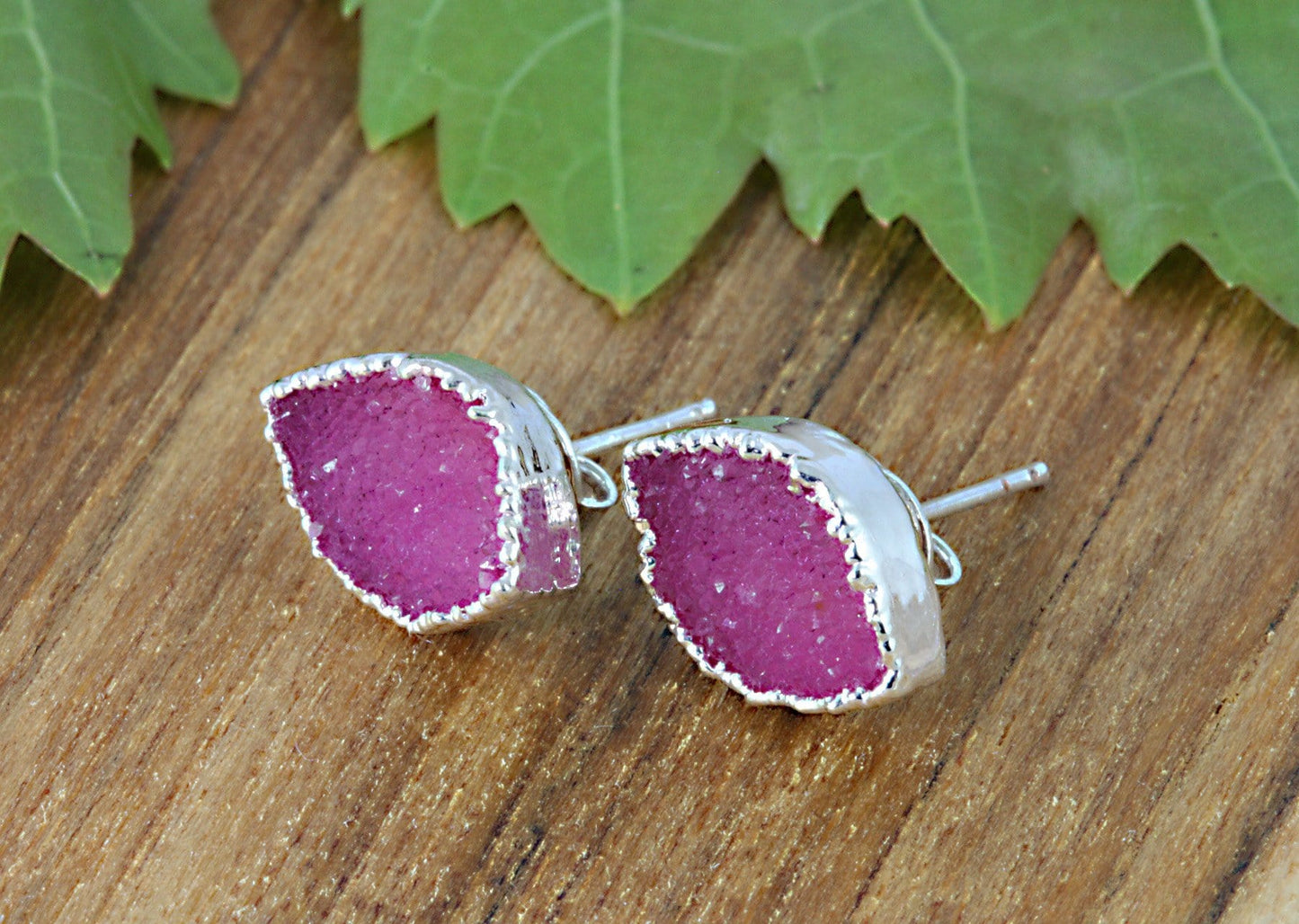 one pink pair of earrings on a table 