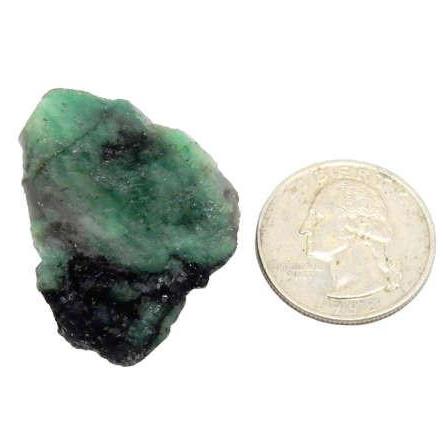 emerald chunk next to a quarter for size reference
