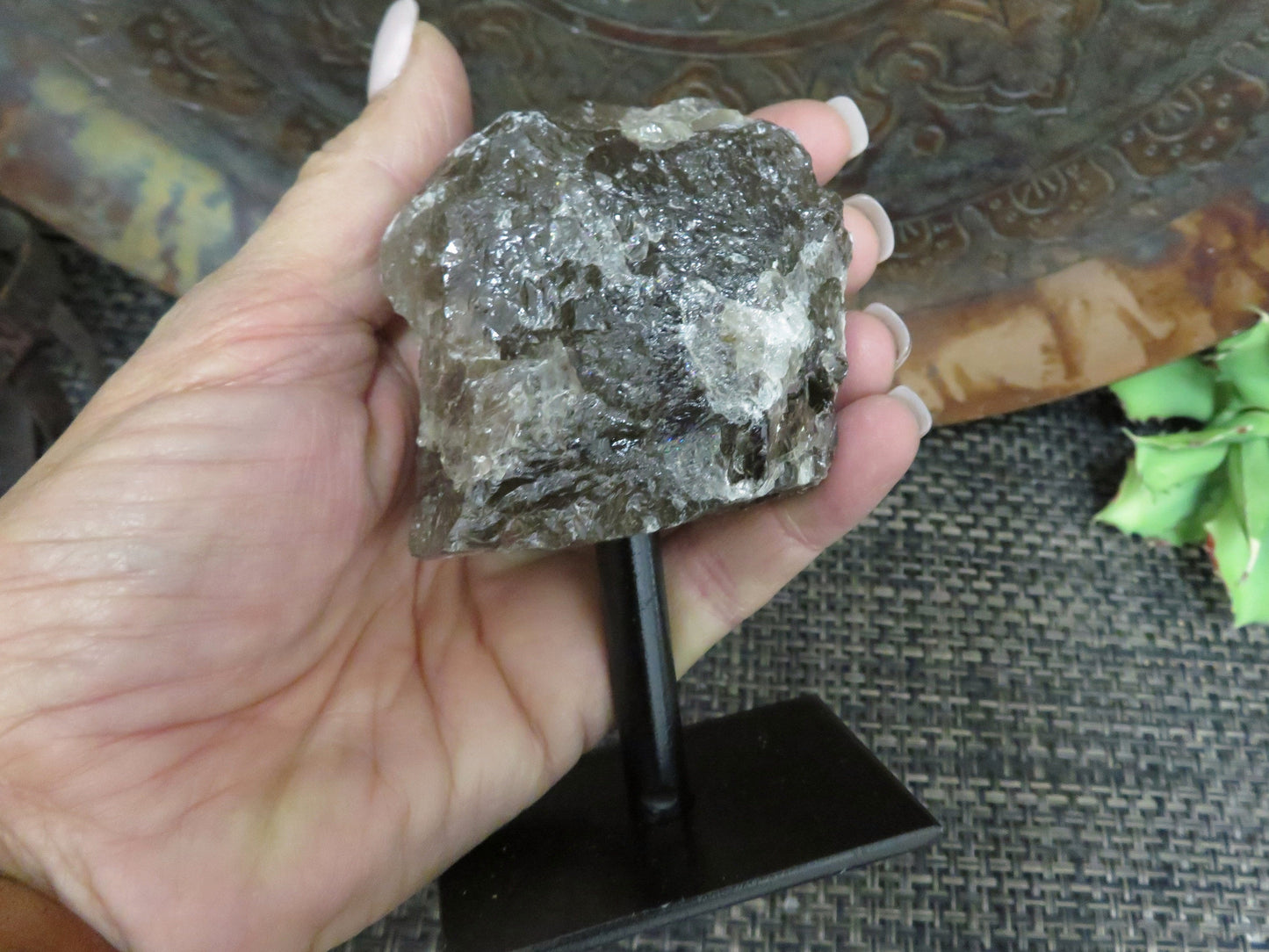 smoky quartz on metal stand with decorations in the background