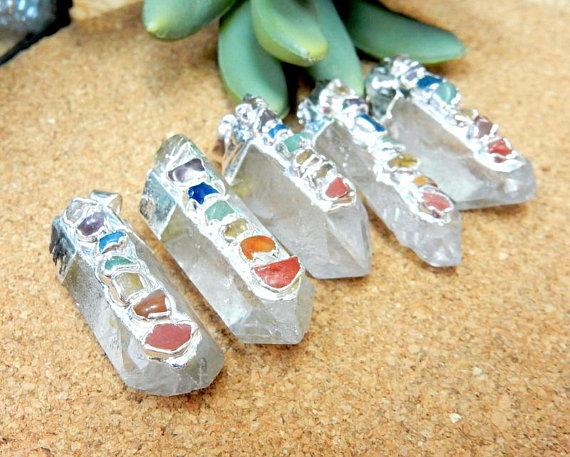 5 silver Crystal Quartz Point Pendants on brown background