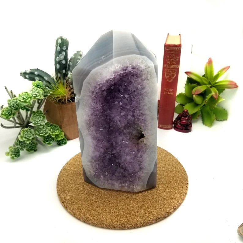 Front view of the amethyst cut base with an amethyst cluster center surrounded by gray and white agate banding.