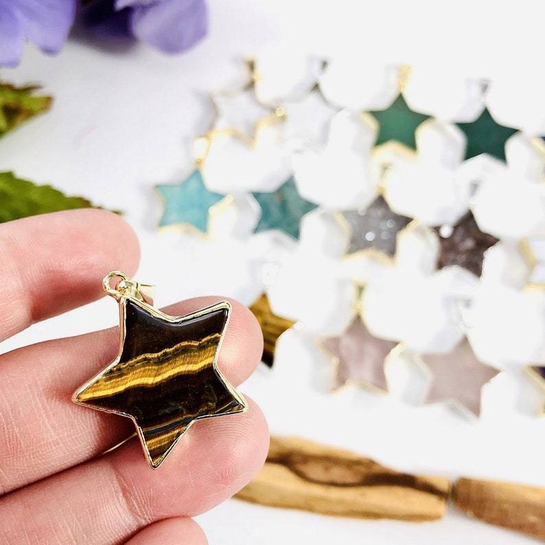 star pendant displayed in hand for size reference