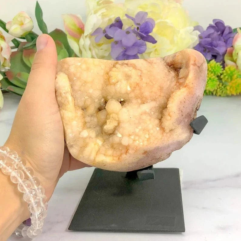 Pink Amethyst Crystal on Metal Stand with a hand for size reference