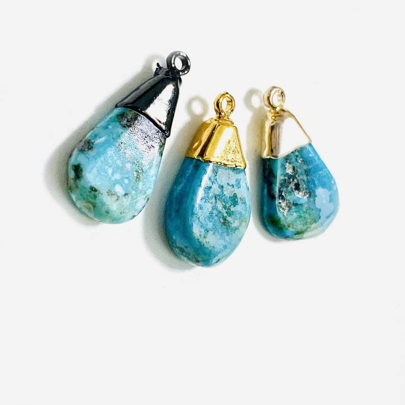 Natural turquoise tear drop pendants.  Pictured in gold plated, silver plated, and black rhodium plated.  They are teardrop shaped and have plating just along the top part.  Small bail, a jumpring would need to be added to make them wearable.
