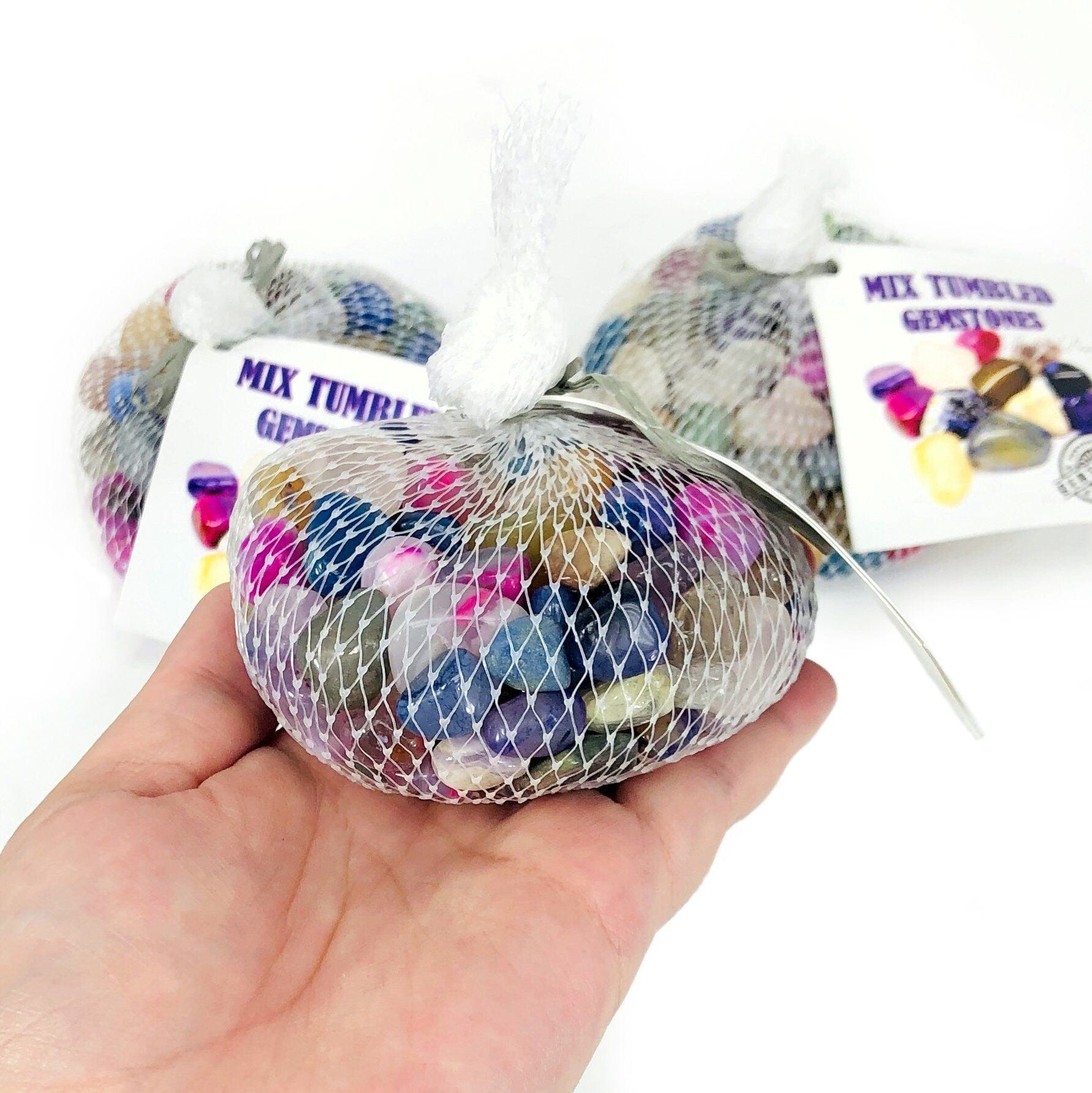 Mixed Small Tumbled Crystals Gemstones Bag in hand with other bags in the background