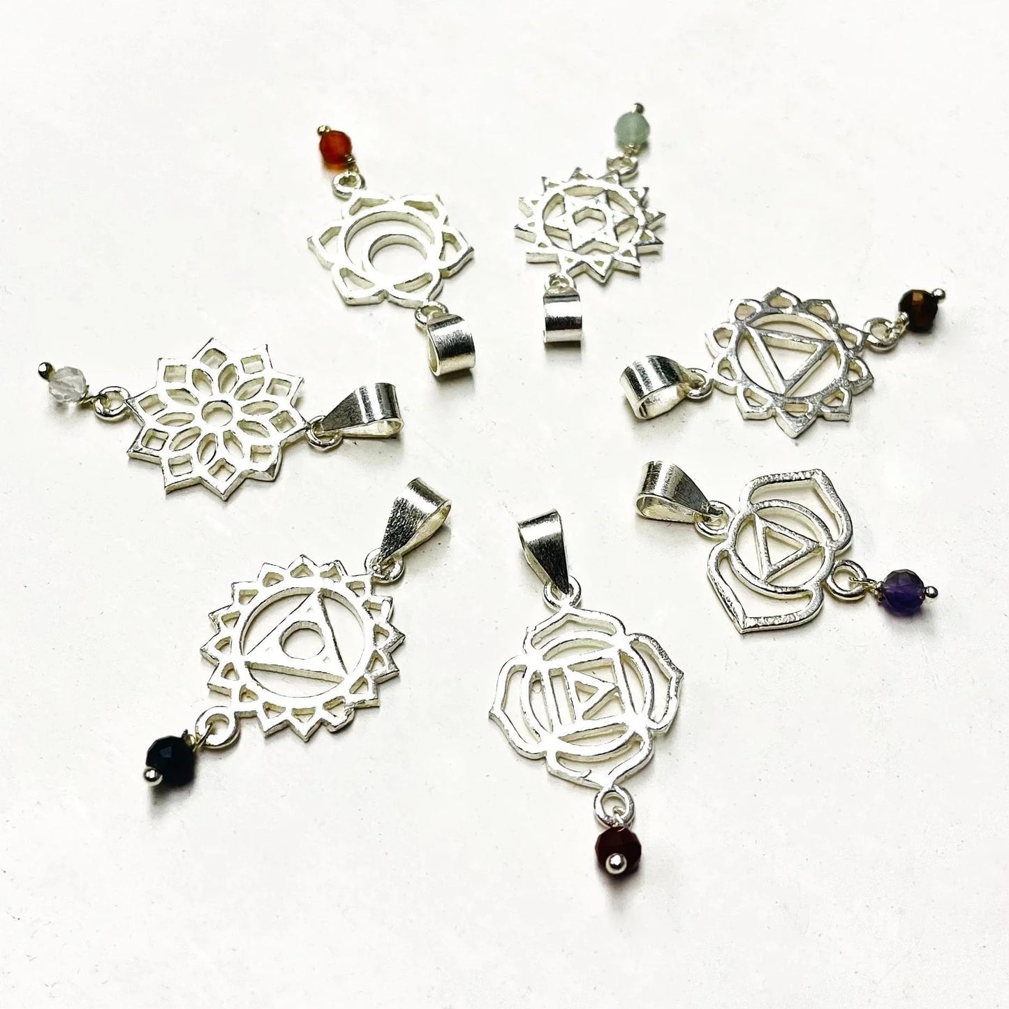 close up of the chakra pendants in silver