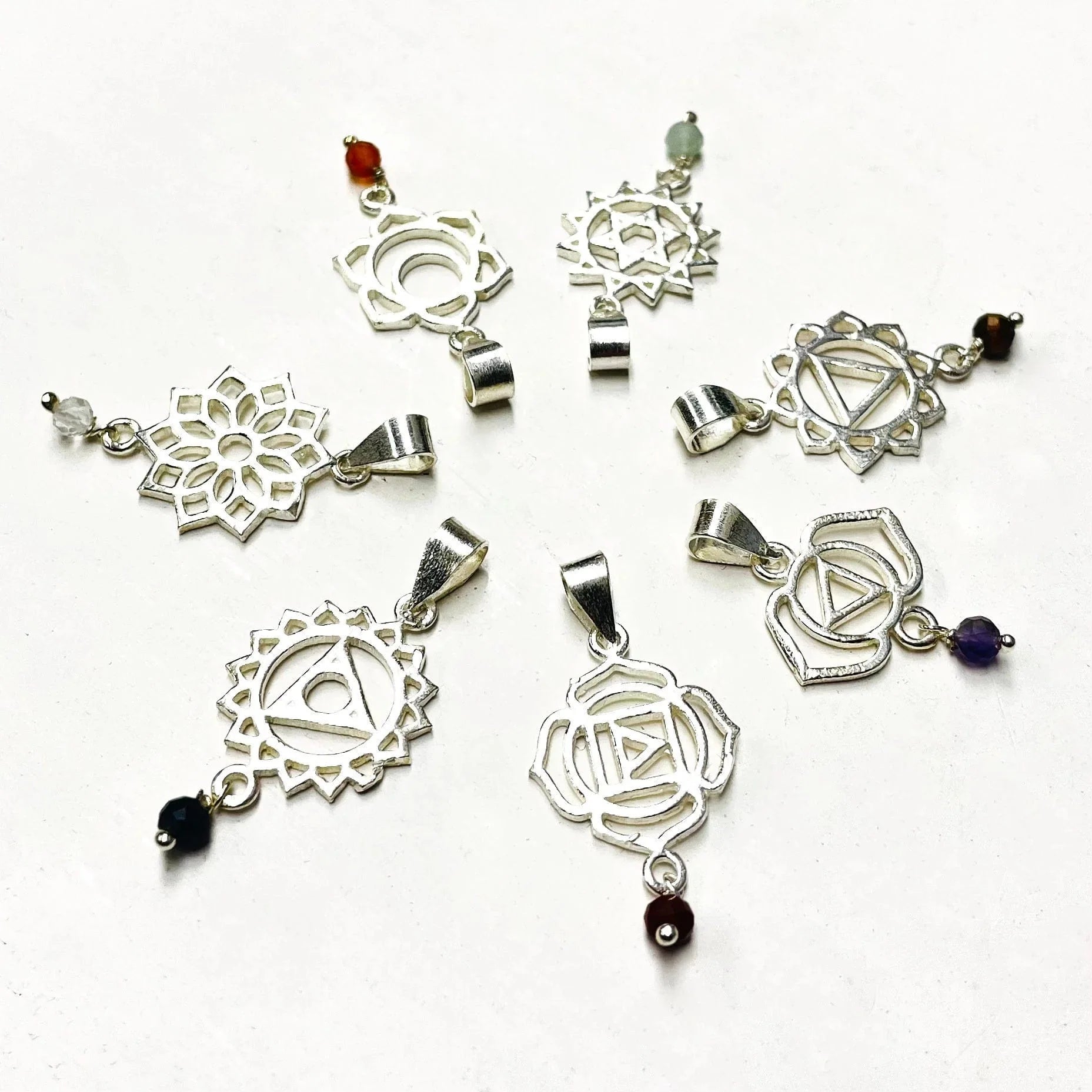close up of the chakra pendants in silver