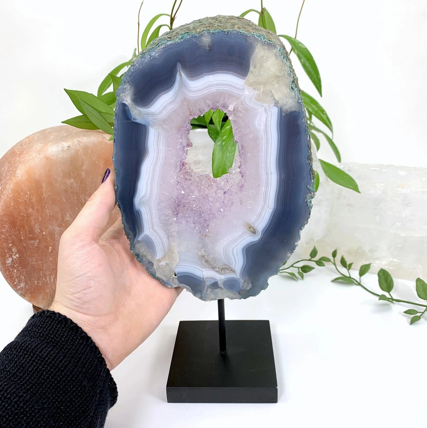 Natural Agate slice with Amethyst Crystal on Wood Stand with a hand for size reference
