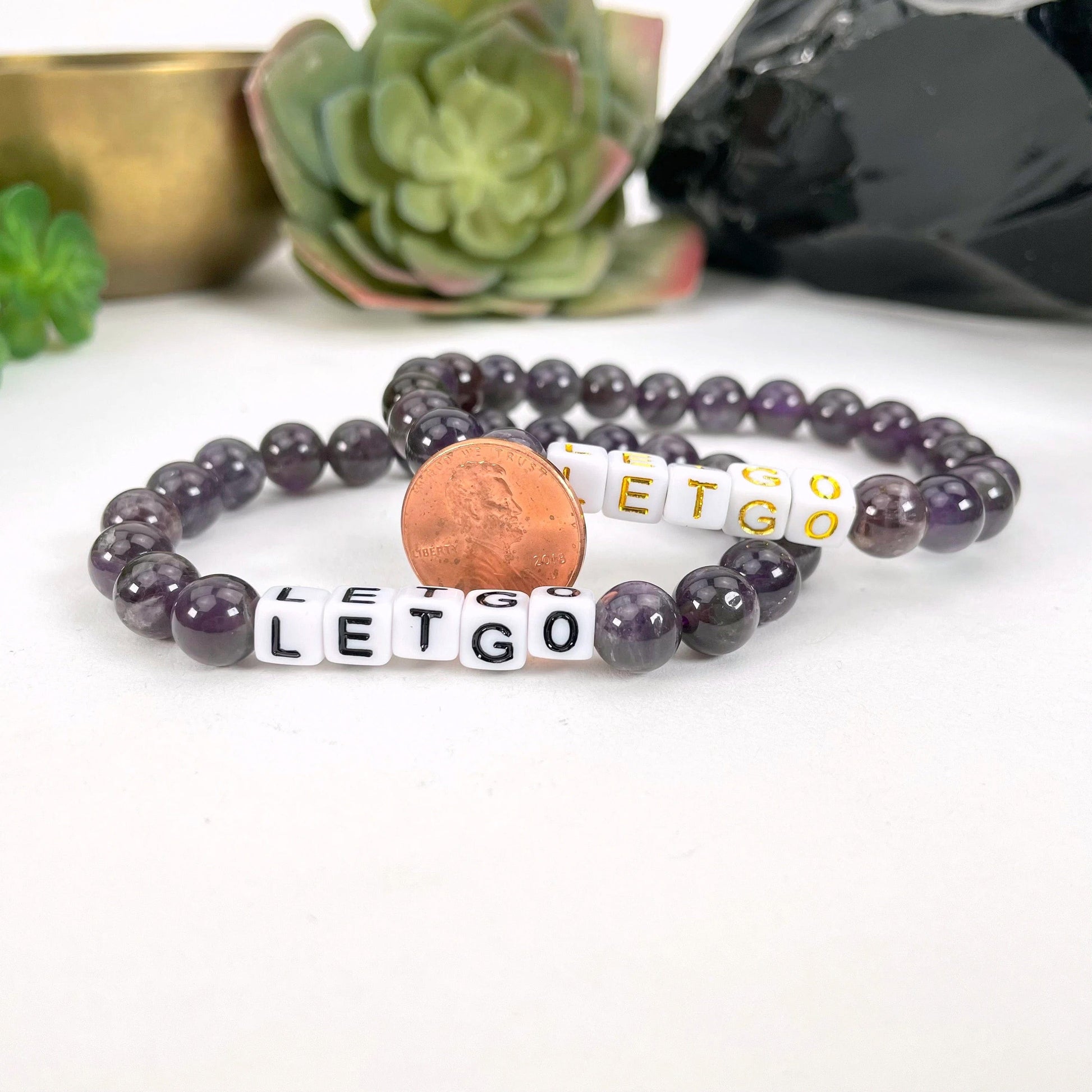 Crystal Mala Bead Bracelet - LET GO -  Letter Beads  in gold and black print next to a coin for size reference