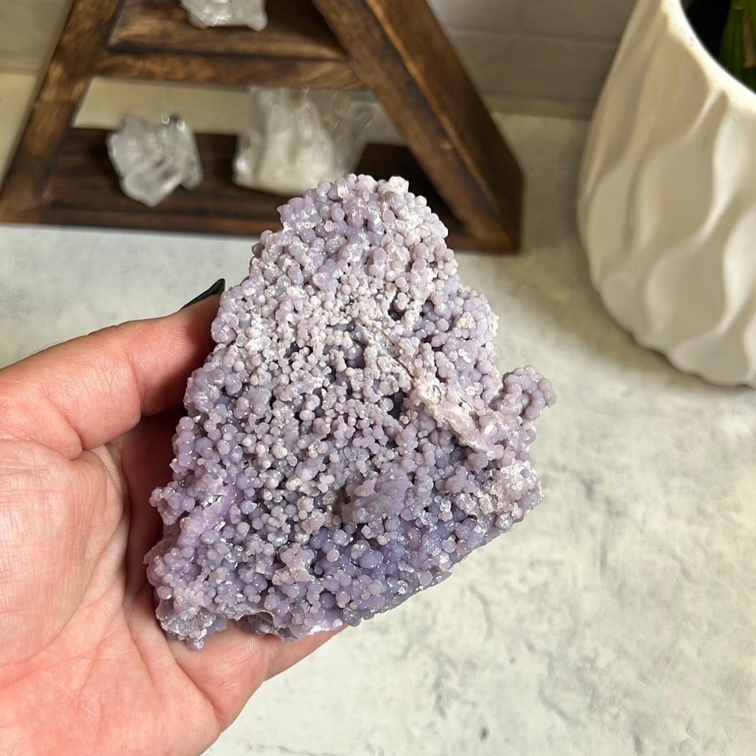 Grape agate formation in a woman's hand.