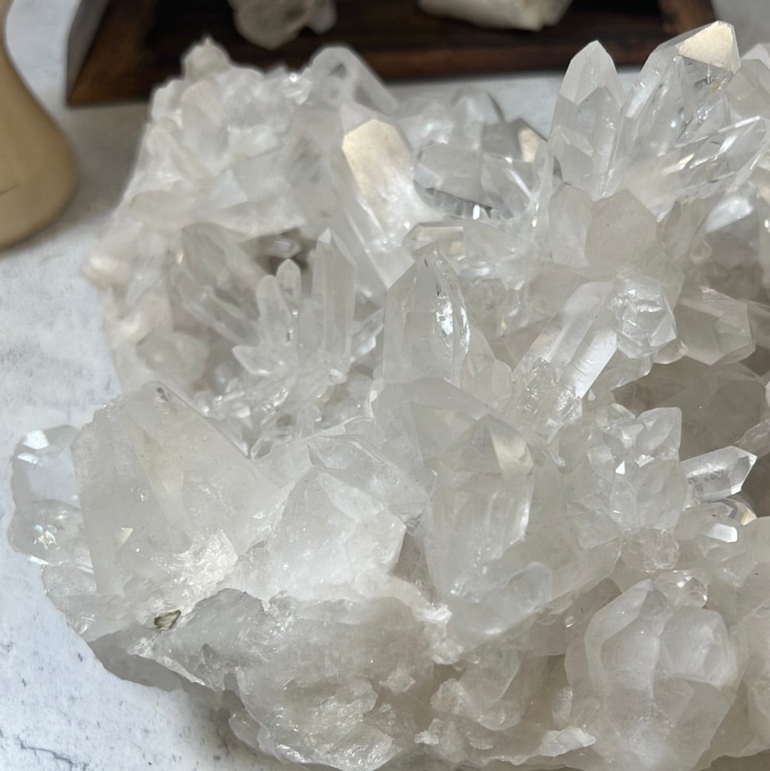close up of Large crystal cluster with points all over it on a cement background.