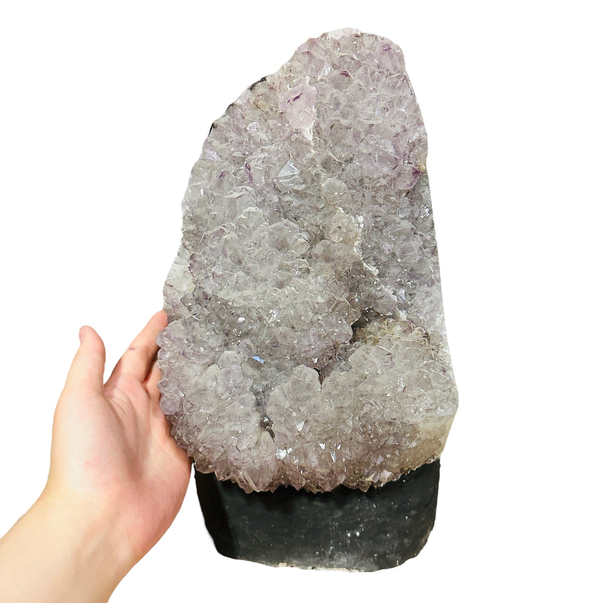 hand next to amethyst decoration for size reference