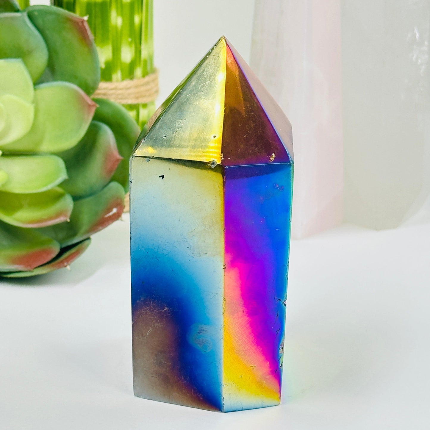 side view of rainbow titanium agate point with decorations in the background