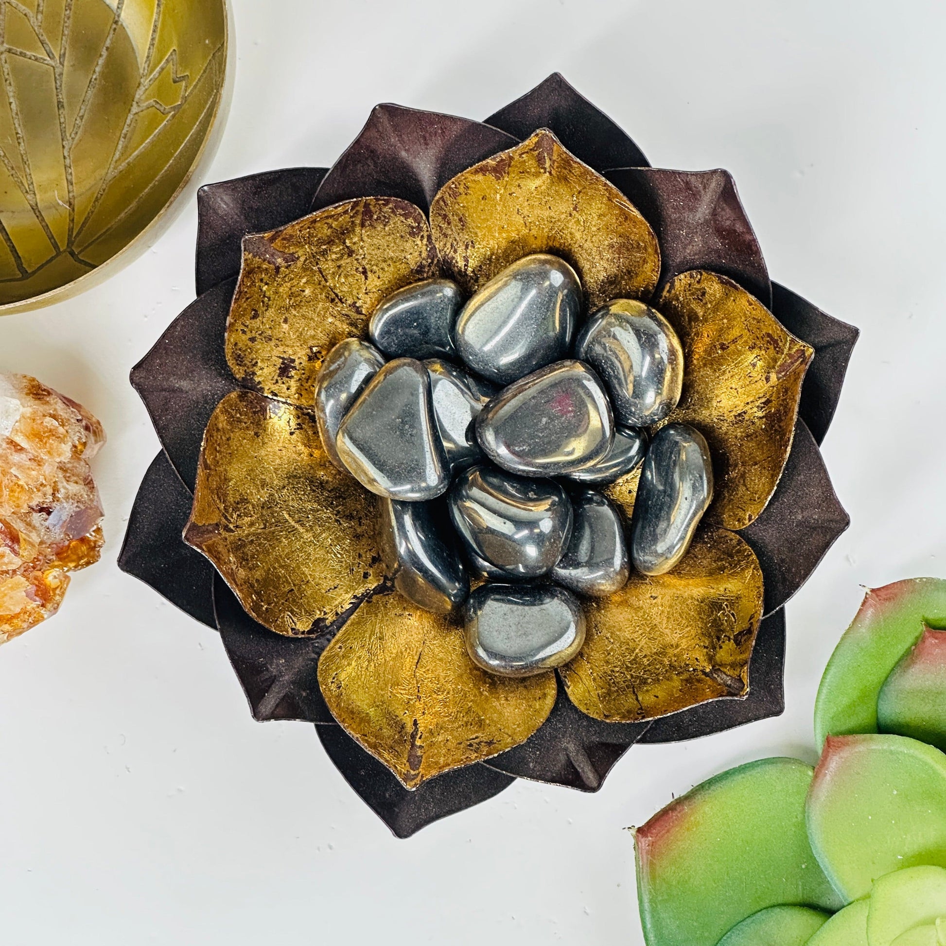 brass lotus bowl filled with hematite silver tumbled stones.