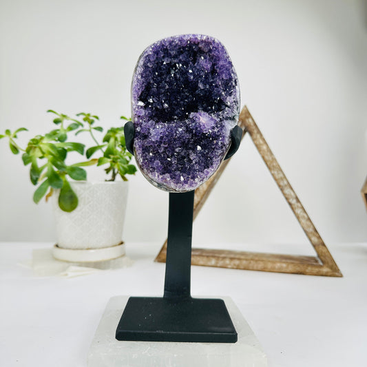 amethyst on metal stand with decorations in the background