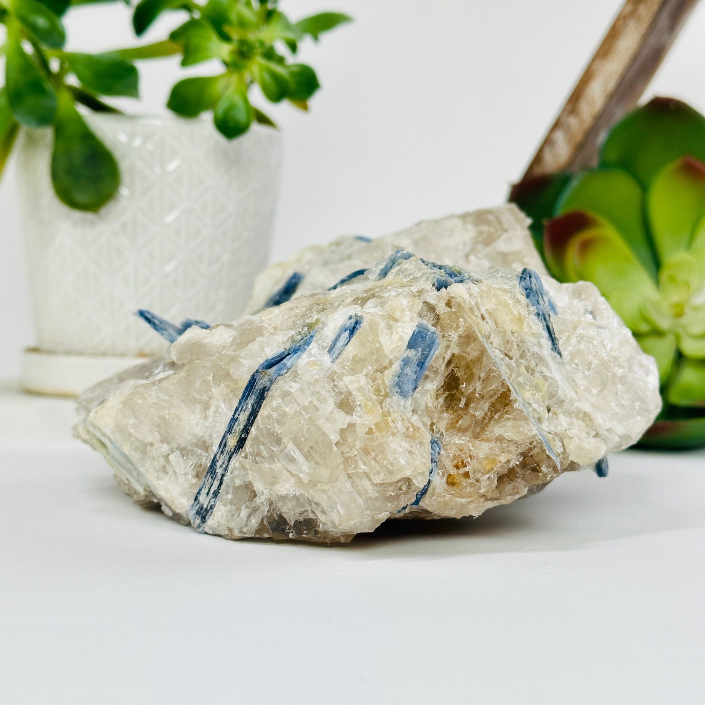blue kyanite on matrix with decorations in the background