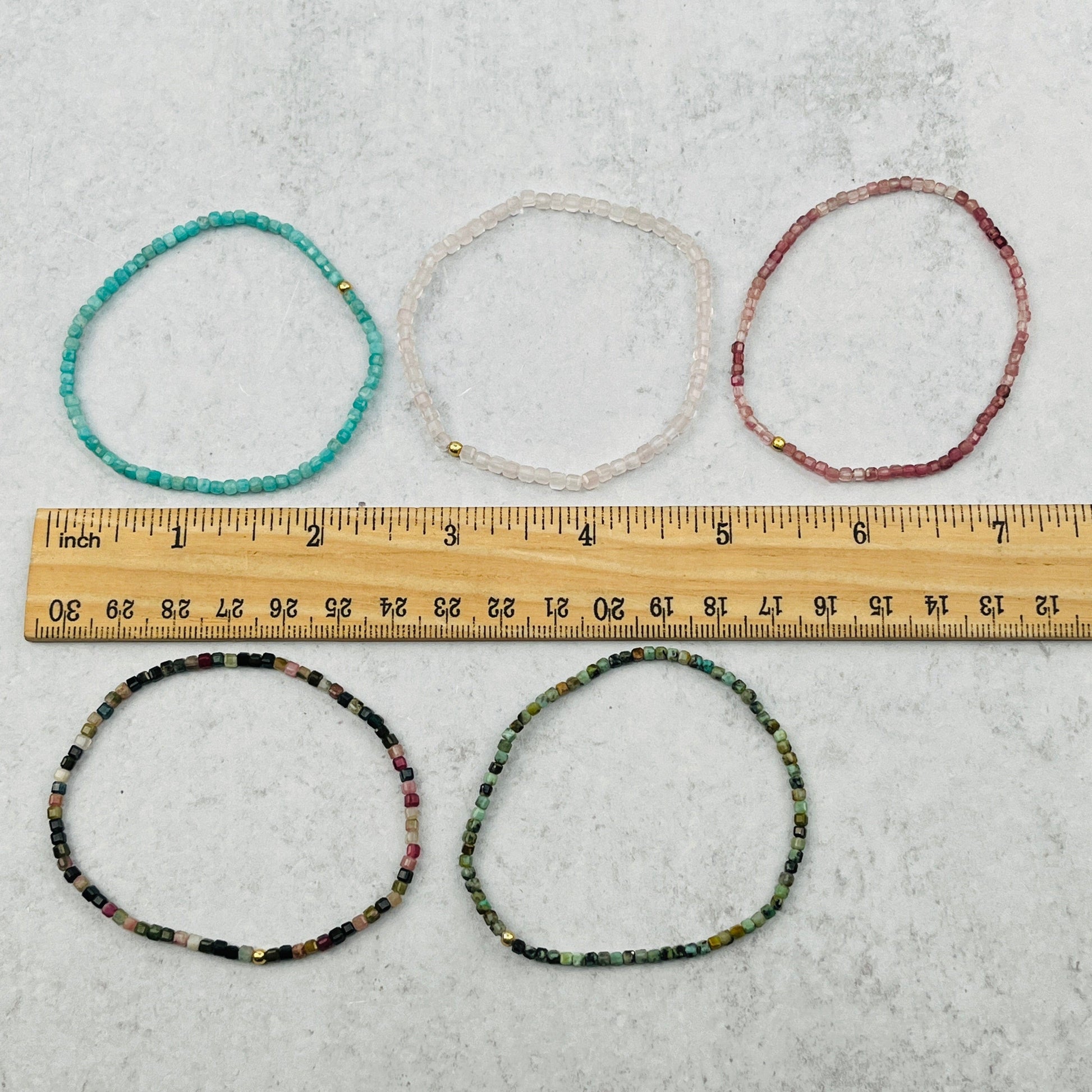 bracelets next to a ruler for size reference 