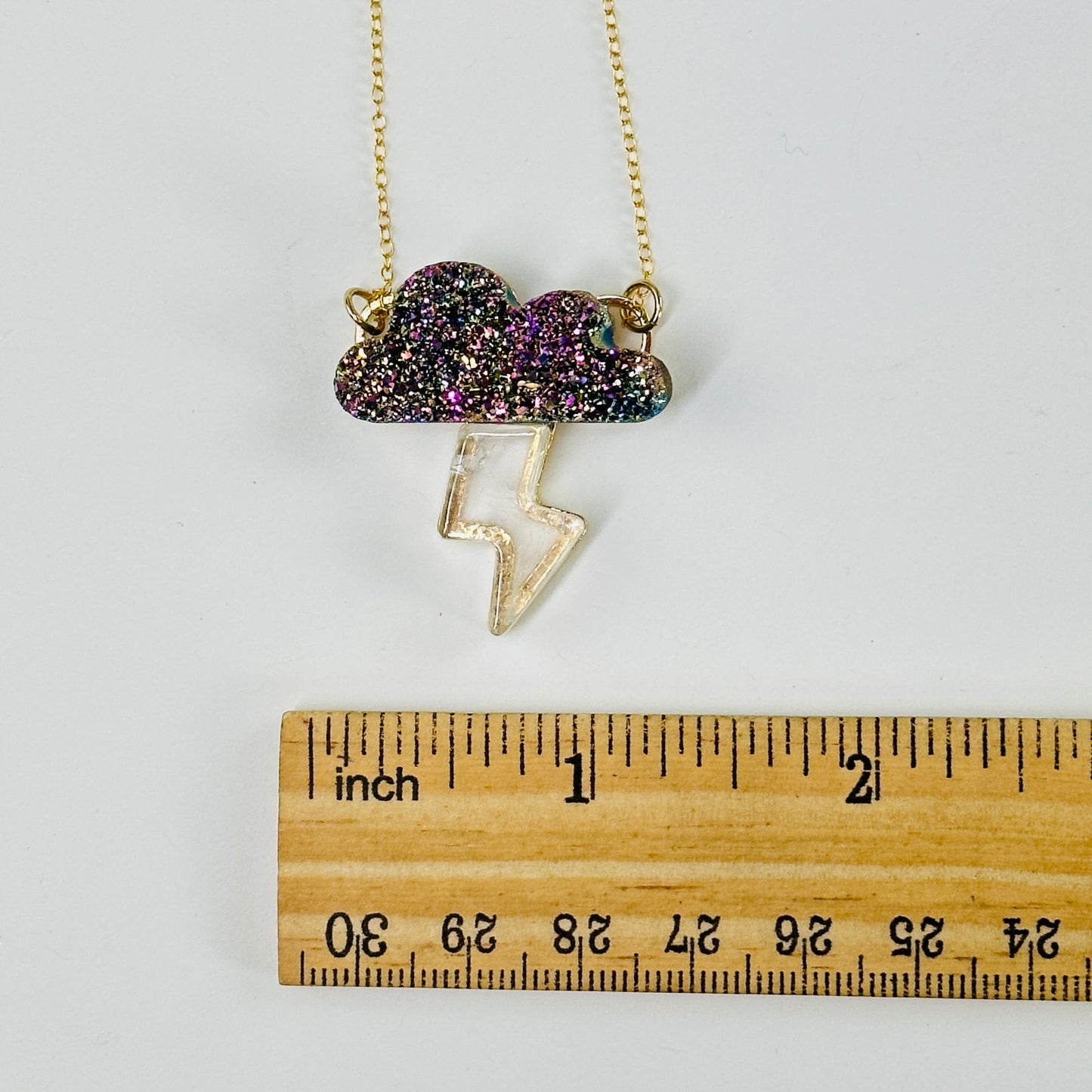 cloud with lightning necklace next to a ruler for size reference