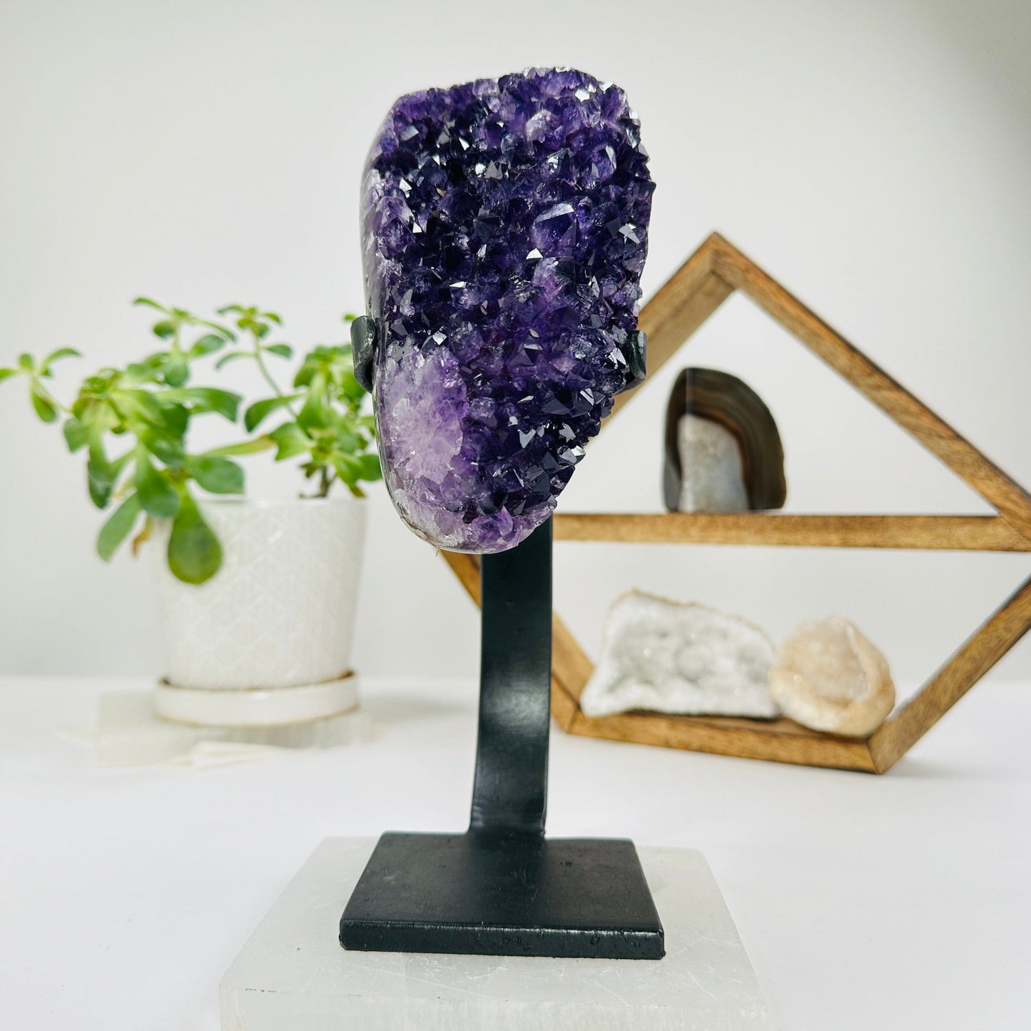 amethyst on metal stand with decorations in the background