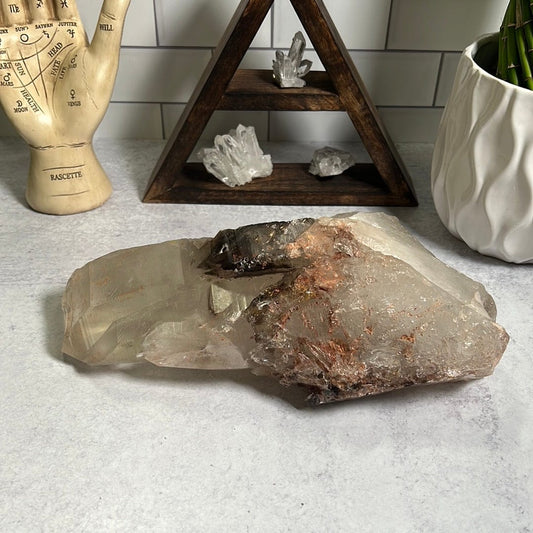 large smokey Quartz cluster on a cement background.
