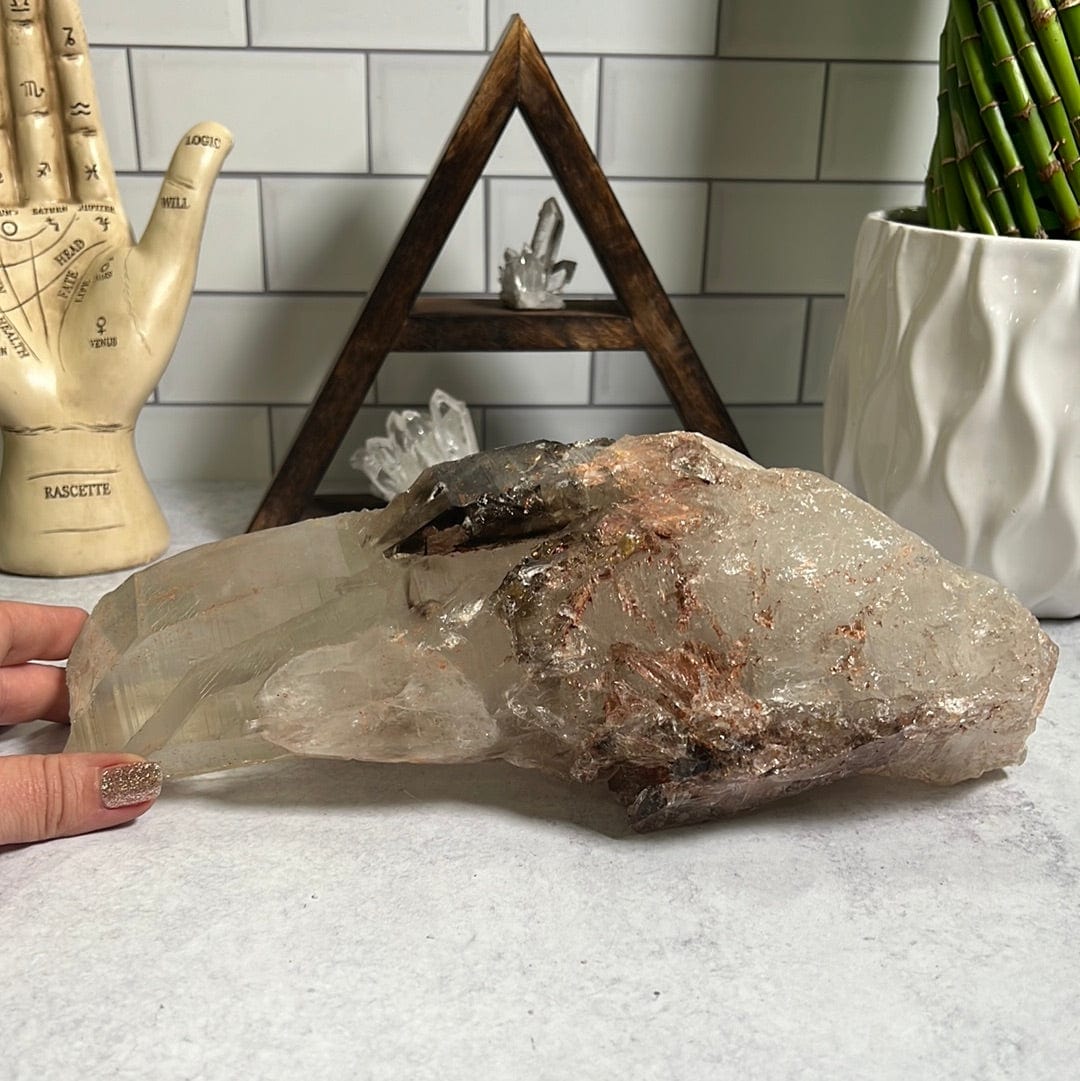 large smokey Quartz cluster on a cement background.